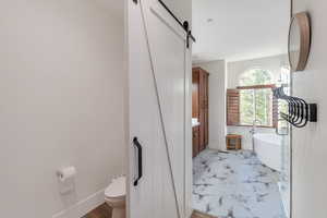 Bathroom featuring a bath, vanity, and toilet