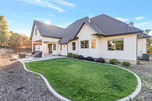 Rear view of property featuring central air condition unit, a patio area, and a yard