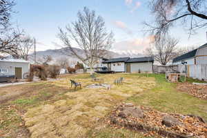 View of yard with a deck with mountain view and an outdoor structure