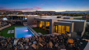 Back house at dusk featuring a patio area and a mountain view