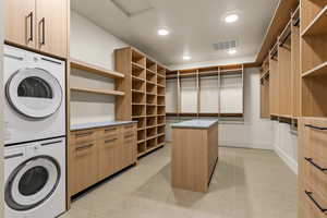 Walk in closet featuring stacked washing maching and dryer