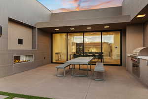Patio terrace at dusk featuring a patio area and an outdoor kitchen
