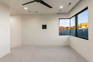 Carpeted spare room featuring ceiling fan