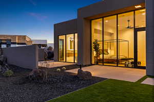 Back house at dusk with a patio area