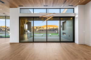 Spare room featuring a mountain view, hardwood / wood-style floors, a healthy amount of sunlight, and wood ceiling