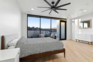 Bedroom with floor to ceiling windows, recessed lighting, light wood-type flooring, ceiling fan, and access to exterior