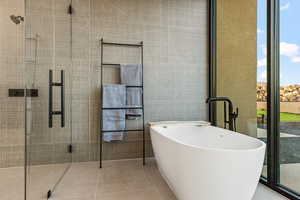 Bathroom with tile patterned floors and a bath