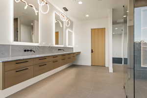 Bathroom with backsplash, tile patterned floors, and vanity