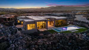 Back house at dusk with a mountain view and a patio