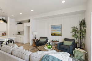 Living room with wood walls and light hardwood / wood-style floors