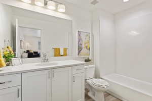 Bathroom featuring toilet, vanity, and hardwood / wood-style flooring