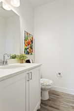 Bathroom with wood-type flooring, vanity, and toilet