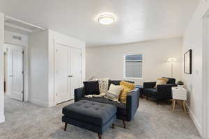 Carpeted living room with a textured ceiling