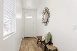 Doorway to outside featuring a healthy amount of sunlight and light wood-type flooring