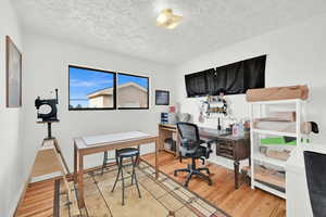 Office space with a textured ceiling and light wood-type flooring