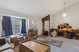 Carpeted living room with lofted ceiling