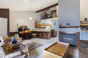 Carpeted living room with vaulted ceiling with beams