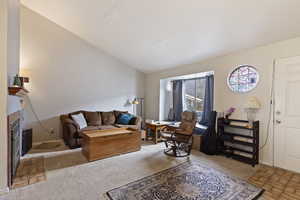 Carpeted living room with lofted ceiling