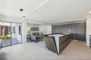 Kitchen with a breakfast bar, pendant lighting, dark brown cabinetry, and black electric cooktop