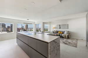 Kitchen with gray cabinets, a kitchen island, and light tile patterned floors