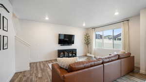 Living room featuring light wood-type flooring and a textured ceiling