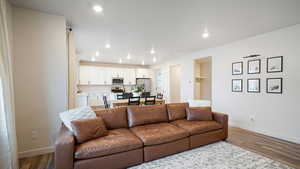 Living room with a textured ceiling and light hardwood / wood-style flooring