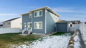 Snow covered property with a lawn