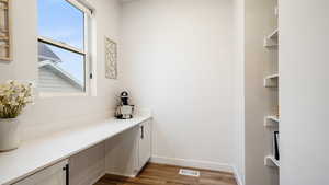 Butler's pantry/pocket office featuring dark hardwood / wood-style floors, shelving, and cabinets