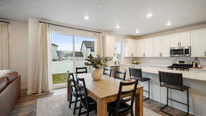 Kitchen featuring stainless steel appliances, white cabinetry, dark hardwood / wood-style floors, and plenty of natural light