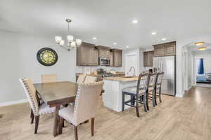 Dining room featuring sink, a chandelier, and light wood-type flooring