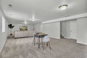 Dining room with a textured ceiling and light carpet