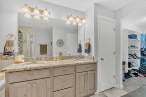 Bathroom with tile patterned floors, vanity, and an enclosed shower