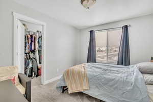 Bedroom featuring light carpet and a closet