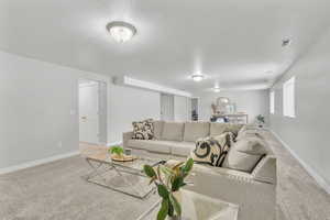 Carpeted living room featuring a textured ceiling