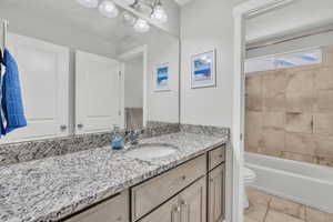 Full bathroom with tile patterned floors, vanity, toilet, and tiled shower / bath