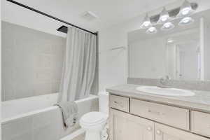 Full bathroom featuring vanity, toilet, and shower / bath combo with shower curtain