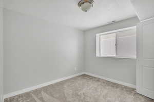 Unfurnished room featuring light colored carpet