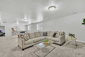 Living room with light colored carpet and a textured ceiling