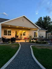 Back of house with a lawn, an outdoor living space, a patio area, and a shed