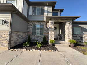Doorway to property featuring a porch and stone siding