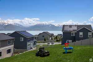 View of yard with central AC unit and a water and mountain view