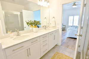 Bathroom with tile patterned flooring, vanity, ceiling fan, and a shower with shower door