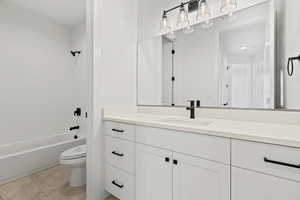 Full bathroom with tile patterned flooring, vanity, toilet, and shower / tub combination