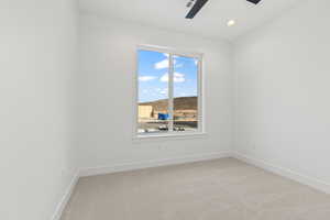 Empty room featuring light colored carpet and ceiling fan