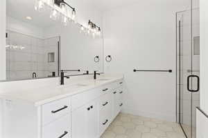 Bathroom with a shower with door, vanity, and tile patterned flooring