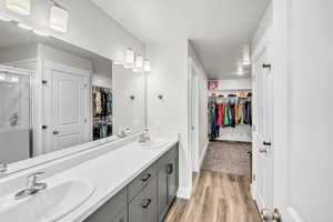 Bathroom with vanity, hardwood / wood-style flooring, and an enclosed shower