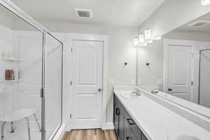 Bathroom with vanity, hardwood / wood-style flooring, and walk in shower