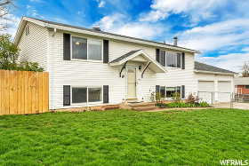 Raised ranch featuring a front yard and a garage