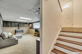 Interior space with carpet flooring, a wood stove, and a paneled ceiling