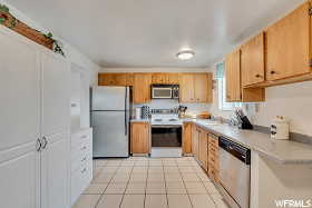 Kitchen featuring light tile patterned flooring and appliances with stainless steel finishes